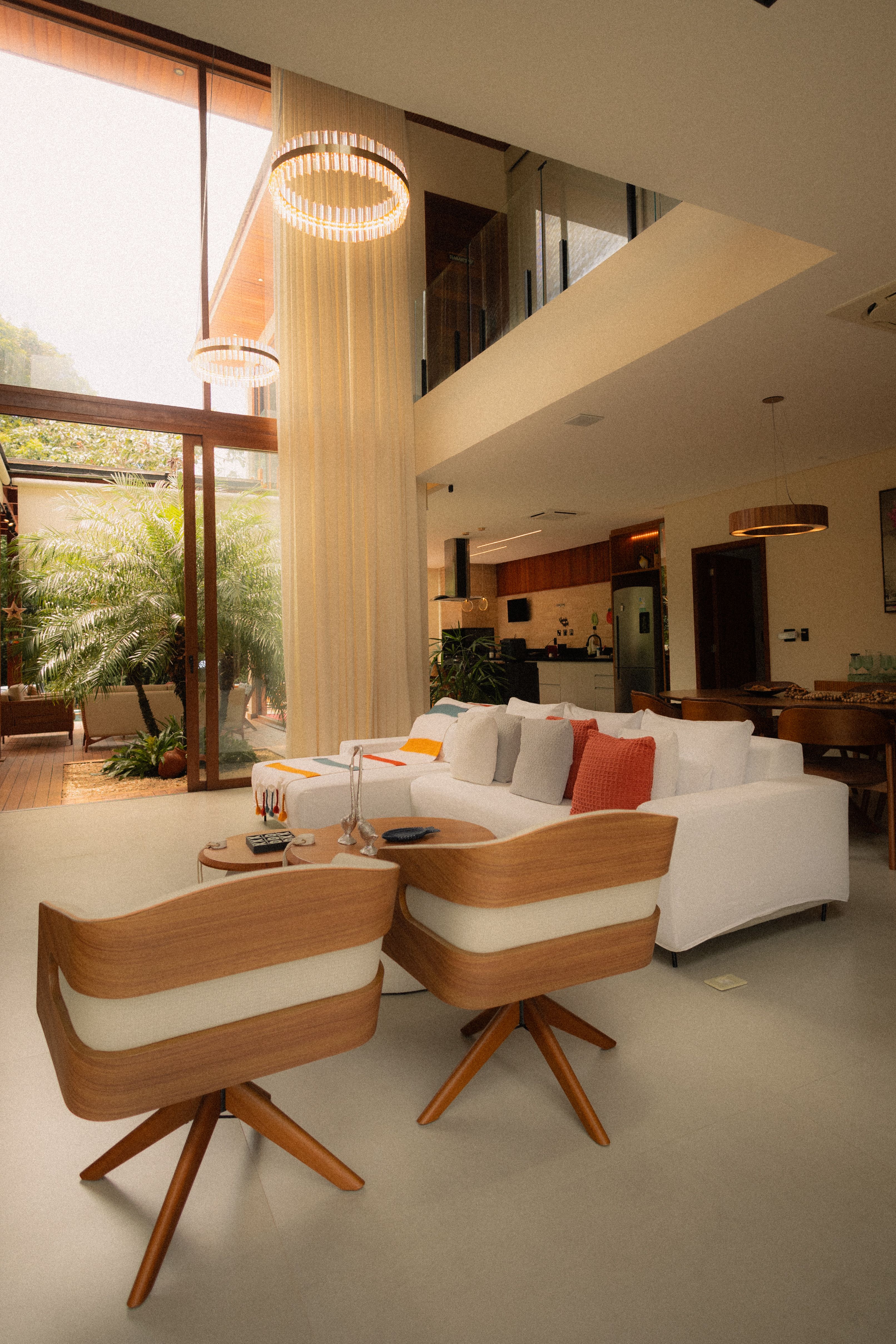 Warm double-height interior with timber furniture and daylight